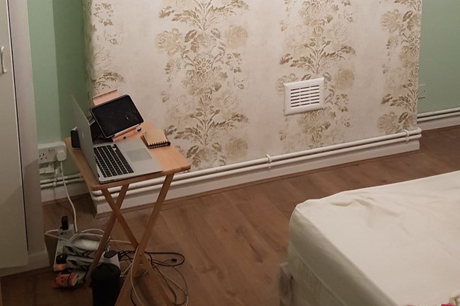 Wallpaper feature in bedroom with a soft green painted walls