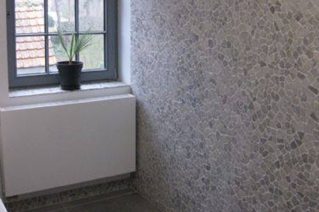plaatsen van natuursteenkeitjes in badkamer