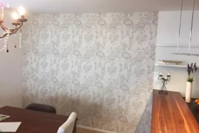 Tapezierarbeiten an der Esszimmerwand -stilvoller Raumteiler