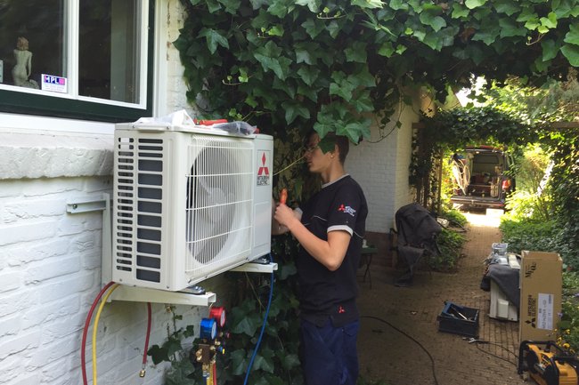 Buitenunit op een buiten muur woonhuis.