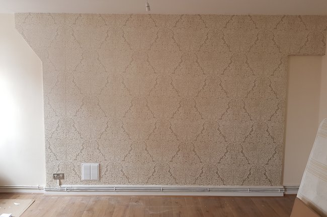 Wallpaper feature in the lounge with magnolia painted walls.