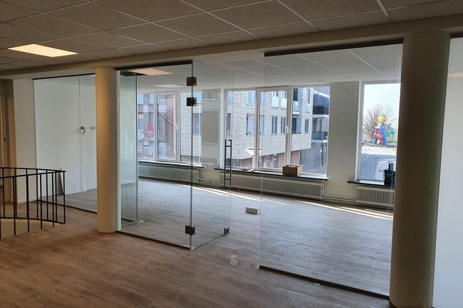 Hardglazen wanden met deur WMC kantoor.