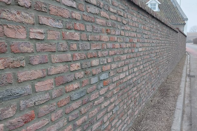 Muur uitgekapt gereinigd en op nieuw gevoegd.
