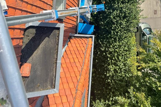 Reinigen en impregneren pannendak met behulp van hoogwerker