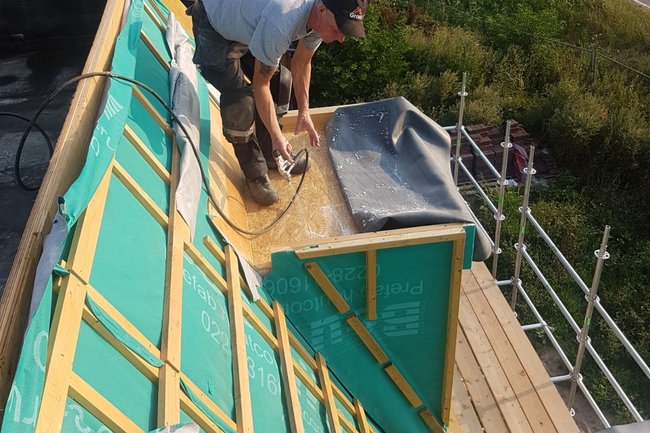 Het plakken van een kleine dakkapel in de nieuwbouw.