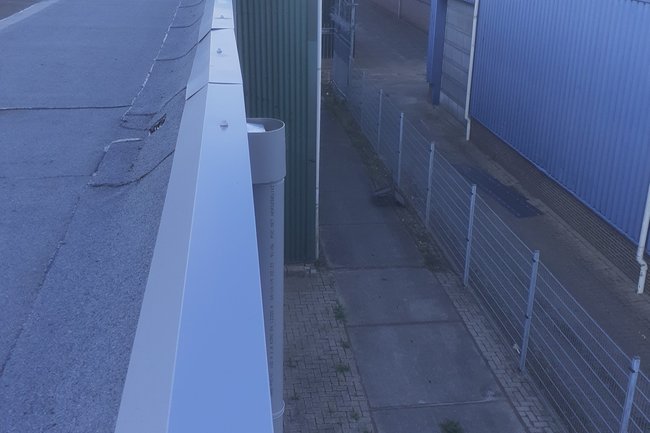Plakken van dakranden op een loods.