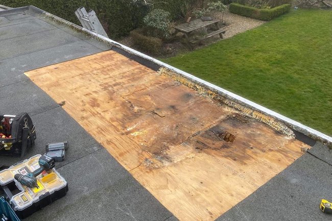 Lekkage van dak op overkapping met schade aan houtbeschot