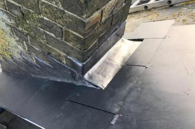 New lead chimney flashing on a man-made slate roof