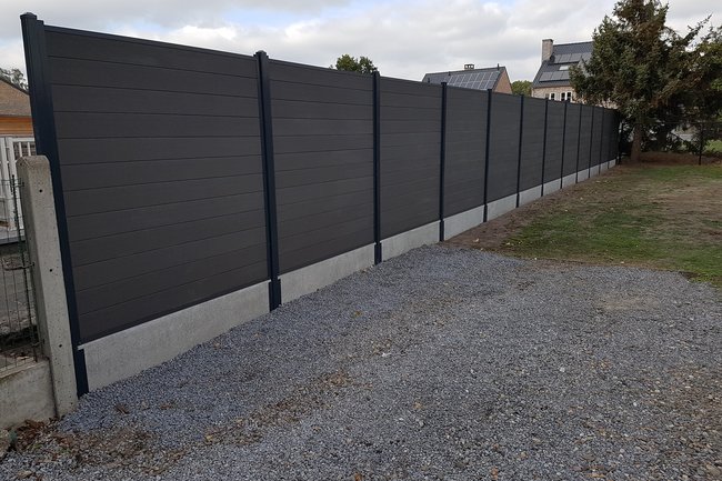 composiete schutting met ijzeren palen en betonplaten.