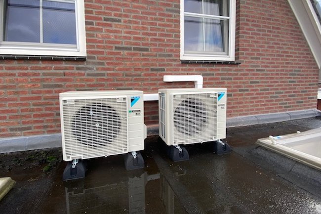 Daikin buitendelen op rubberen montagevoeten.